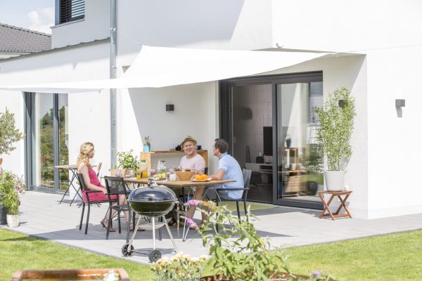 Insektenschutz Plissee an großer Terrassentür, Menschen sitzen draußen auf der Terrasse
