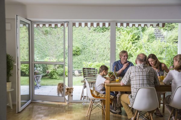 Insektenschutz Pendeltür an Terrassentür, Familie sitzt gemeinsam am Esstisch bei geöffneter Tür